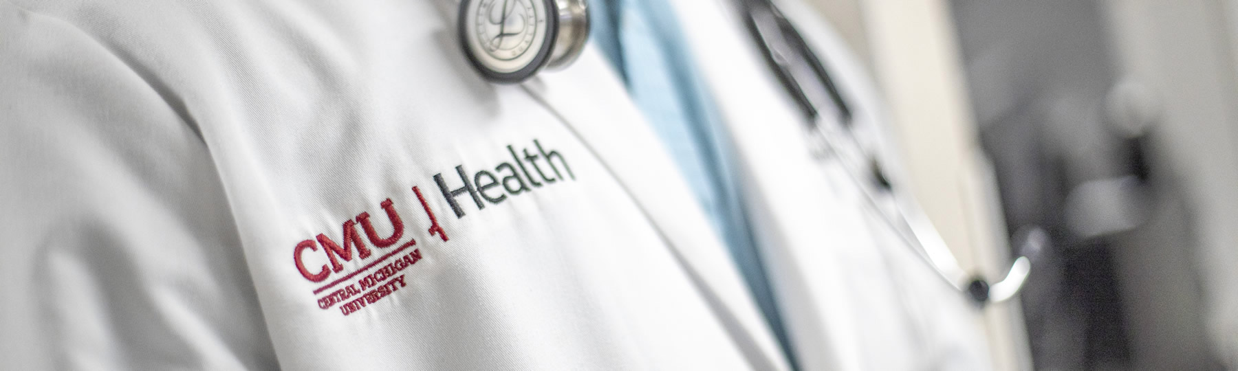 Person wearing a CMU Health lab coat and stethoscope.