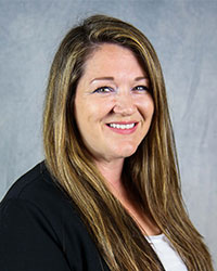 Woman with long hair smiling for professional headshot.