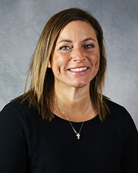 A woman wearing a black shirt smiles for a headshot.