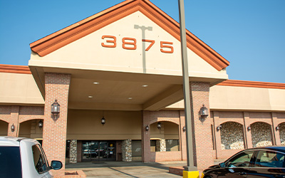 Exterior image of a building with an orange roof and brick front.